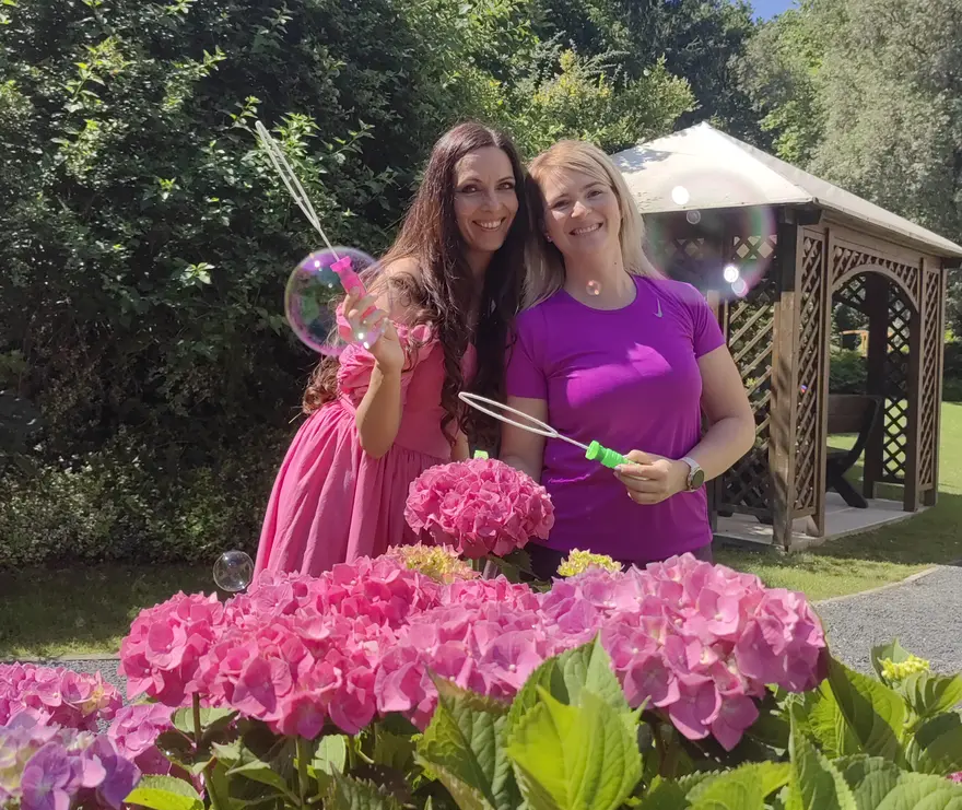 Damen machen Seifenblasen im Garten des Vitalhotels.