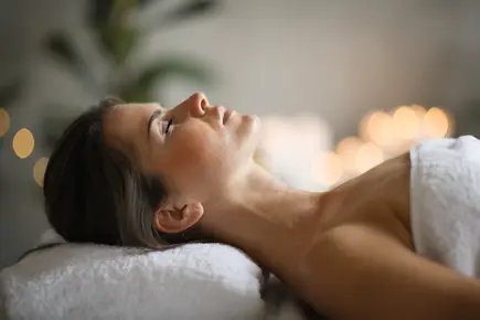 Dame liegt entspannt auf einem Massagetisch im Vitalhotel. Dame liegt entspannt auf einem Massagetisch im Vitalhotel.